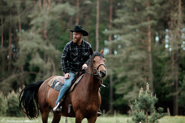 cowboy man in hat riding horse across meadow	