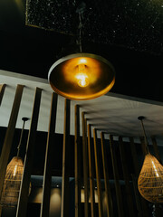 Stylish pendant lights glowing warmly in a contemporary café with wood accents and modern design aesthetics.