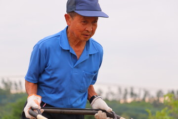 畑を耕すシニア男性　農家のおじさん