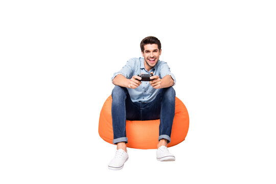 Full length body size photo of trendy man addicted to playing video games wearing white sneakers holding joy stick with hands isolated over grey color background - Powered by Adobe