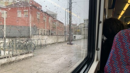 Raindrops on a train window reveal a quaint European town, autumn travel and cozy holiday vibes 