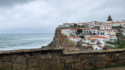 Rustic coastal village with whitewashed houses atop cliffs, scenic seascape panorama, travel and...