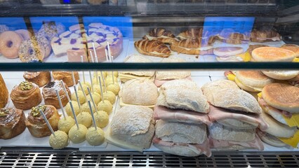 Assorted pastries and sandwiches in a bakery display, ideal breakfast, brunch, festive gatherings,...