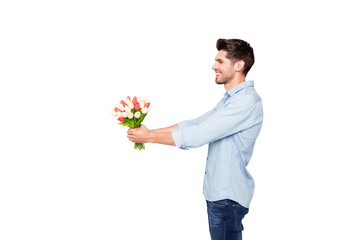 Profile side photo of positive cheerful man lover have fun give tulips bouquet to his girlfriend on 8-march 14-february date copyspace have fun wear stylish clothes isolated over grey color background