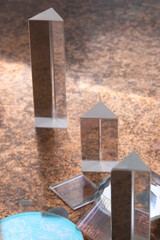 Three triangular glass objects are on a brown surface