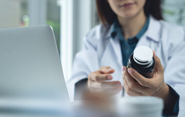 Closeup, medical doctor holding medicine bottle and checks for accuracy on the antibiotics and...