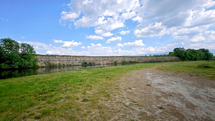 Panoramic view of an eroded riverbank along the Maritsa River in Bulgaria, with cloudy skies and...