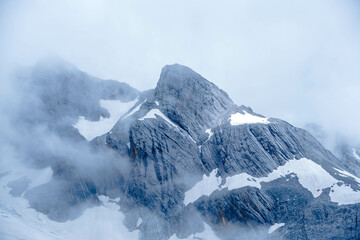Snow - Capped Mountain Peak Enshrouded in Mist