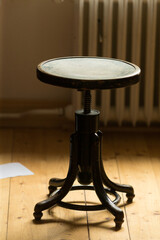 This vintage wooden stool features a rounded seat and ornate base, perfect for enhancing stylish...