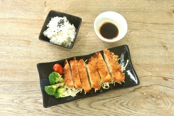 fried chicken with bred flour or Karaage Japanese food topping vegetable with rice dressing black sesame dipping sweet black soy sauce