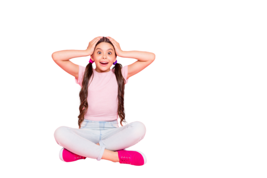 Portrait of cute kid sitting screaming touching head with hands shouting dressed white pants trousers t-shirt isolated over pink background