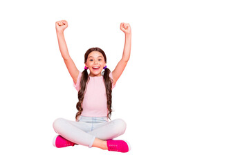 Portrait of delighted child raise fists scream shout yeah sitting dressed white pants trousers...
