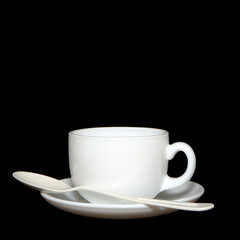cup and saucer with spoon closeup shot on black background