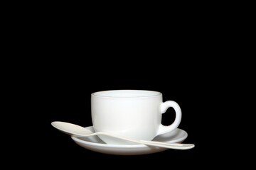 cup and saucer with spoon closeup shot on black background