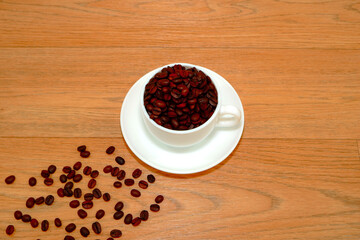 coffee mug with coffee beans closeup view on wooden background 