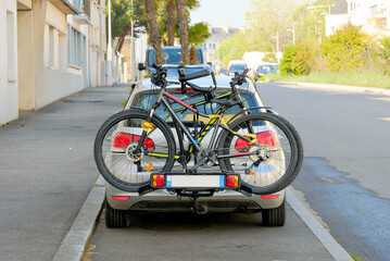 Car with Bicycle Rack Loaded with Two Bikes in Urban Area