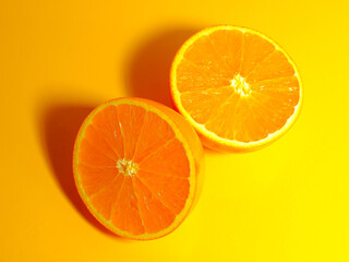 Sliced orange fruit isolated on yellow background closeup view