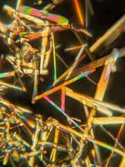 Needle-like crystals under polarized microscope showing vivid birefringence