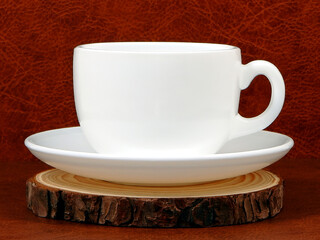 cup and saucer on wooden plate with brown background