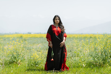 Women wearing red and black dress posing in mustard feilds, shoot for kaar kash