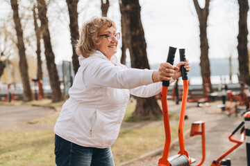 Senior woman exercising with equipment in outdoor gym