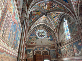 Interior of the Basilica of Saint Francis of Assisi with colorful frescoes by Giotto on the walls and ceiling. Italy.