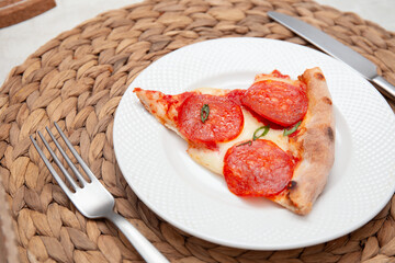 Angled View of Pepperoni Pizza Slice on White Plate