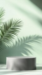 Obraz premium Minimalist product display with soft green backdrop featuring elegant palm leaf casting delicate shadow on clean cylindrical pedestal