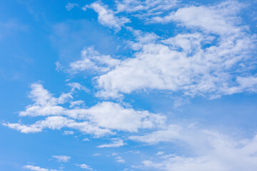 Obraz premium Bright blue sky with fluffy white clouds drifting across, forming a calm and picturesque atmosphere in nature.