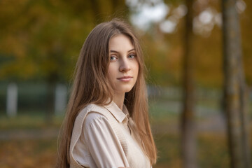 Portrait of a young beautiful girl with a pleasant smile in a city park.