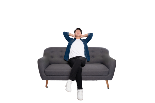 Full body image of young Asian man using phone sitting on sofa on PNG background	