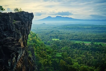Fototapeta premium Dramatic clifftop vista overlooking lush valley and distant mountains