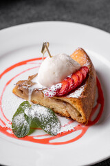 A beautifully plated dessert sits gracefully on a pristine white plate, showcasing layers of pastry complemented by fresh strawberries and a dollop of ice cream