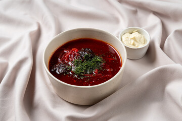 Vibrant bowl of borscht showcases deep red hues accented by fresh herbs, served alongside a dollop of creamy garnish. This culinary delight embodies heartwarming comfort and tradition