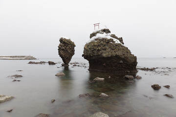 rocks in the sea wit torii gate