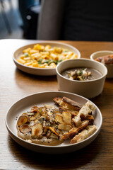 Colorful and artistic dishes are beautifully arranged on wooden tables, showcasing gourmet culinary creations. The atmosphere is inviting, perfect for food enthusiasts and casual diners alike