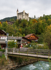 Fototapeta premium Capture the tranquil beauty of Lake Lauenen in the Bernese Oberland during autumn. The lake's emerald waters mirror the vibrant hues of surrounding forests, where golden larches and fiery maples
