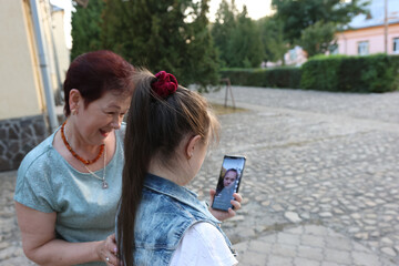 Mother and daughter with Down syndrome looking at their photos on a smartphone.