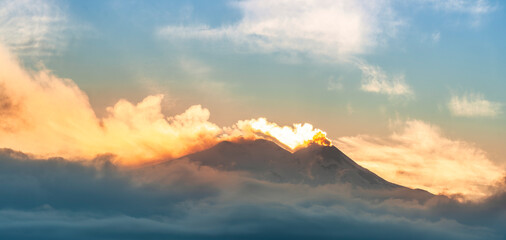mysterious mountain in sunset orange and blue clouds in evening light with slopes with snow and...