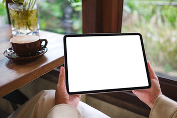 Mockup image of a woman holding digital tablet with blank white desktop screen