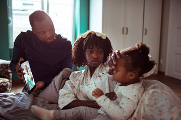 Young family talking to their pediatrician over a video call on the digital tablet
