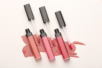 Lipstick and applicator wand on pastel pink backgrpund. Liquid lip stick open tube. Makeup cosmetic...