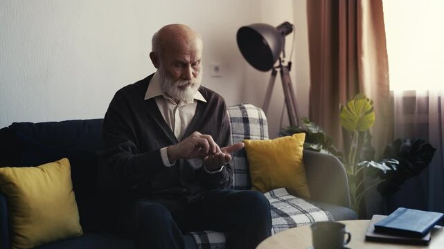 Unhappy elderly man counting coins in hand, low pension and financial hardship