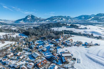 Der Wintersportort Ofterschwang im Oberallgäu an einem sonnigen Tag aus der Luft