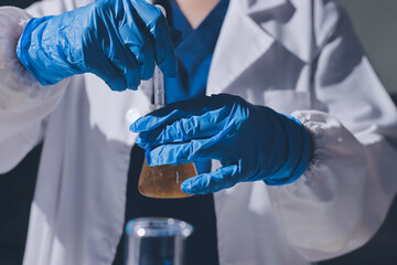 Scientist pipetting medical samples into microplate in laboratory