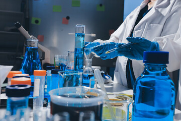 Scientist pipetting medical samples into microplate in laboratory