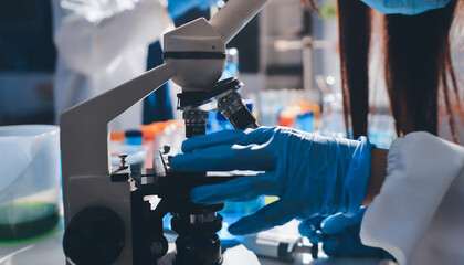 Scientist pipetting medical samples into microplate in laboratory