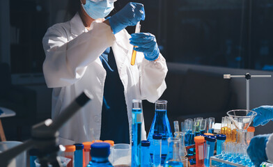 Scientist pipetting medical samples into microplate in laboratory