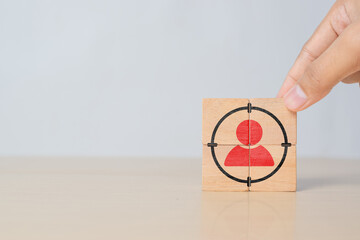 Hand putting wooden cubes with focused on target customer symbols. Target customer, buyer persona,...