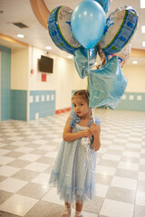 little girl with balloons indoors